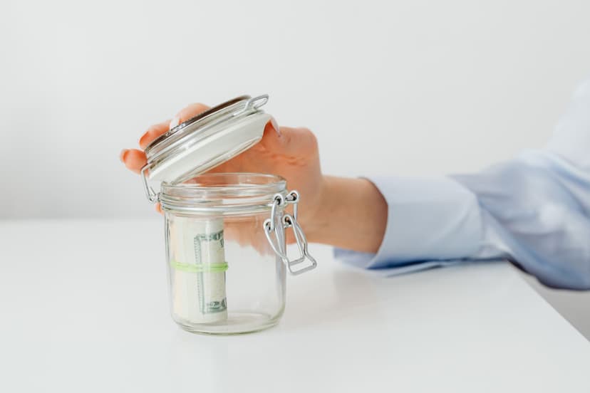 Pièces de monnaie déposées dans un bocal en verre, symbole d'épargne
